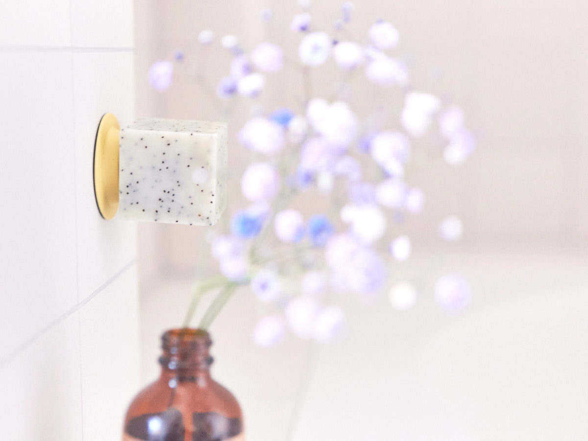 Gelber Soapi mit Seife neben einer Vase mit Blumen